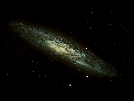 Спиральная галактика NGC 253, видимая почти с ребра